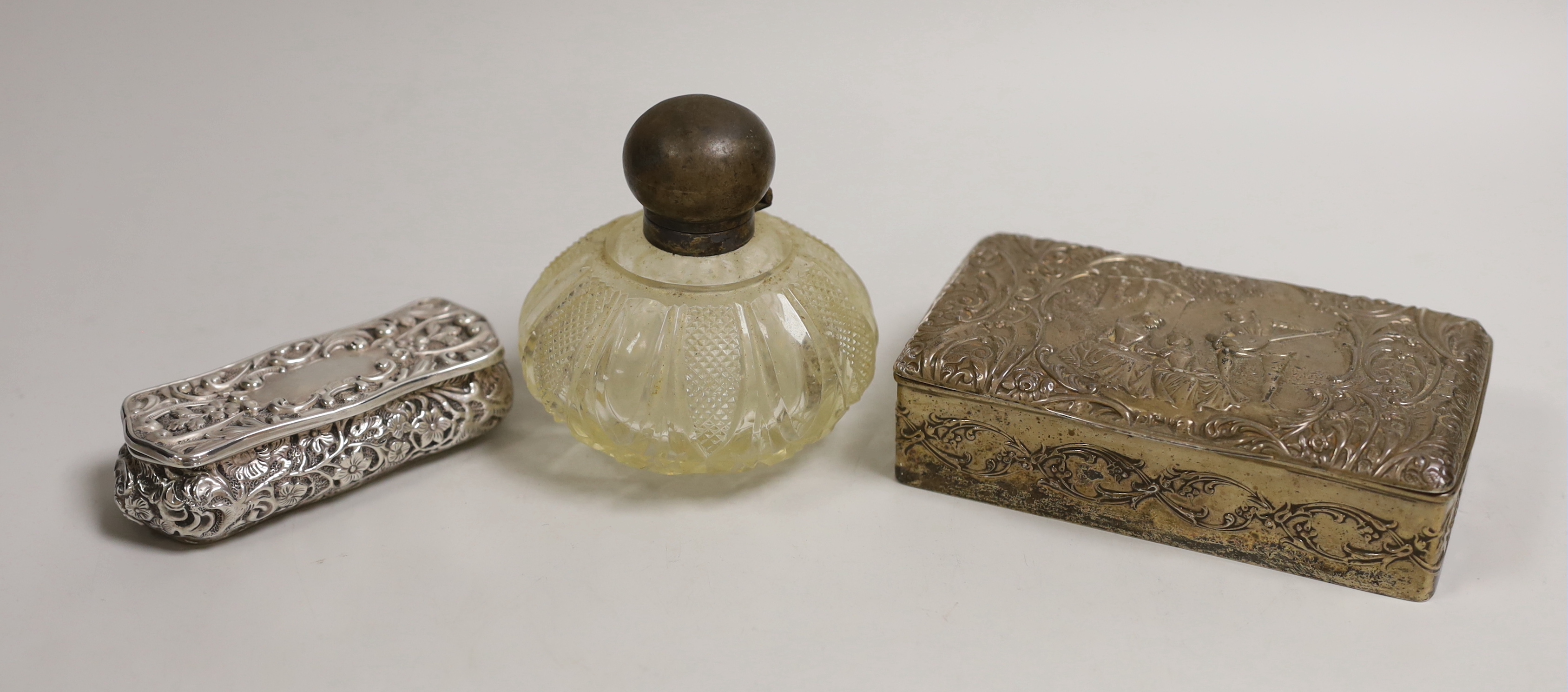 An Edwardian repousse silver mounted trinket box, Birmingham, 1904, 13.8cm, one other smaller repousse box and a silver topped glass scent bottle.